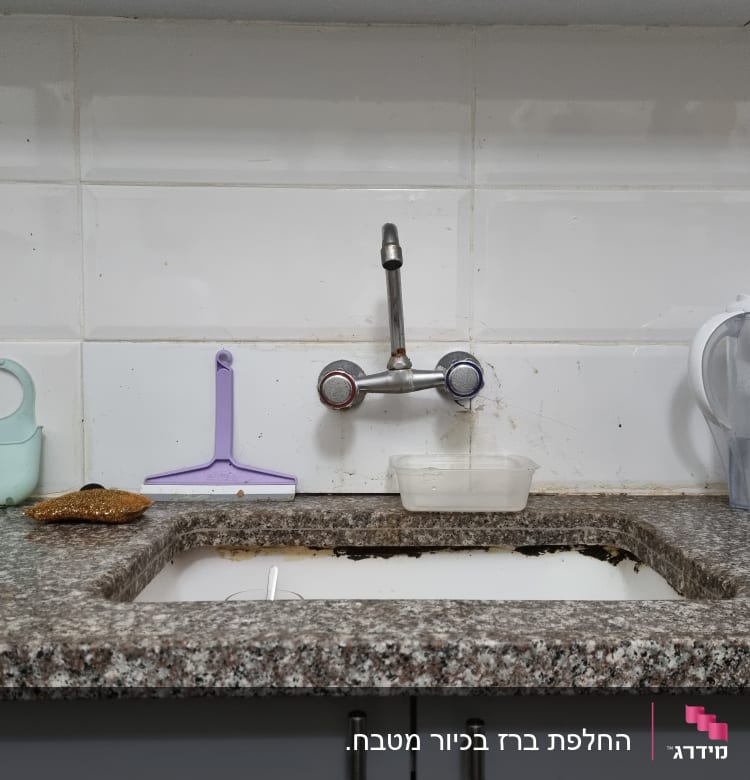 ברז מטבח עם כיור ומיכל פלסטיק מתחתיו